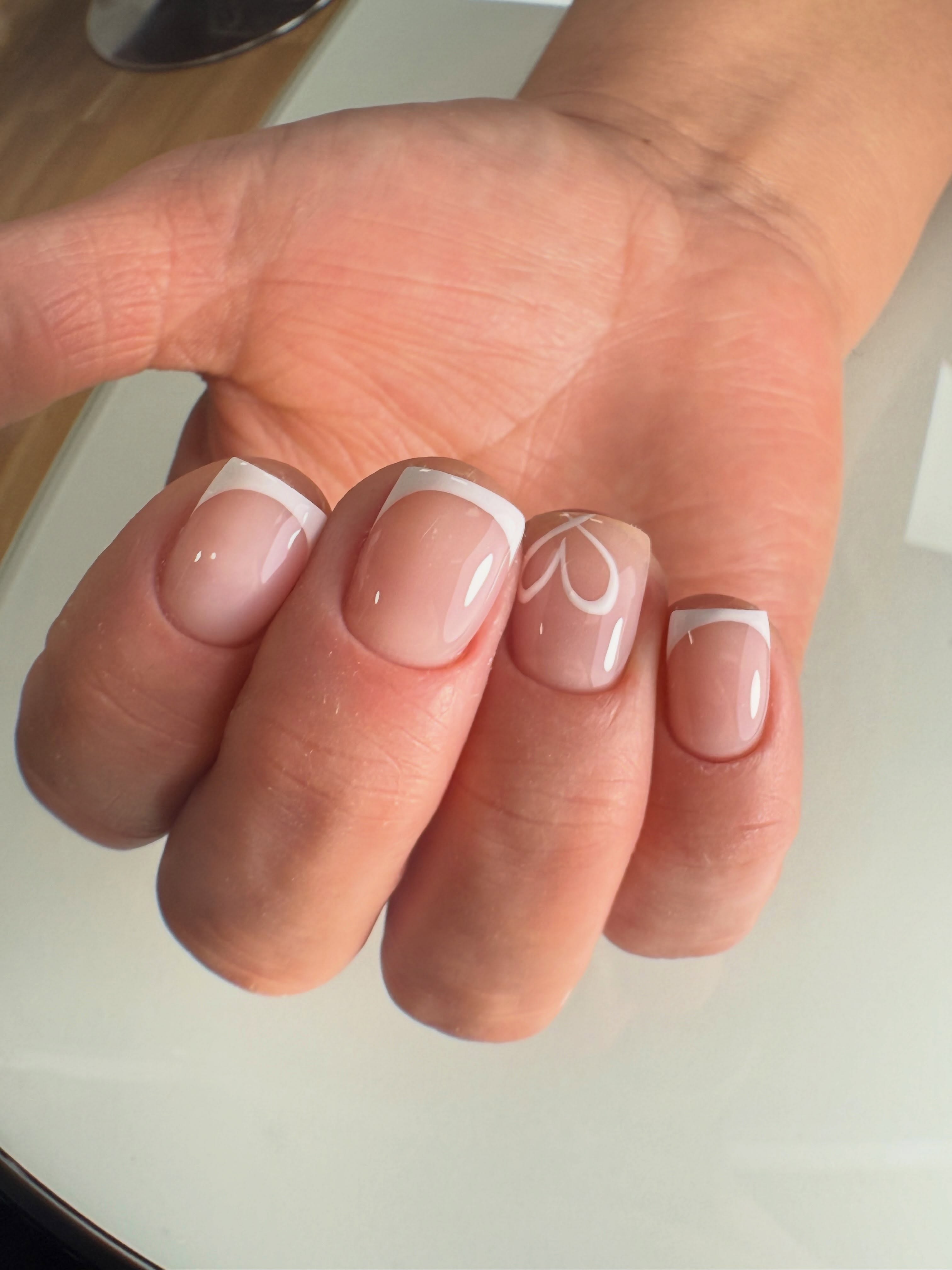 Cuatro uñas rosadas con puntas blancas y un detalle lineal
