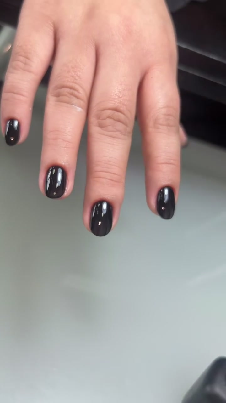 Mano con cuatro uñas negras brillantes