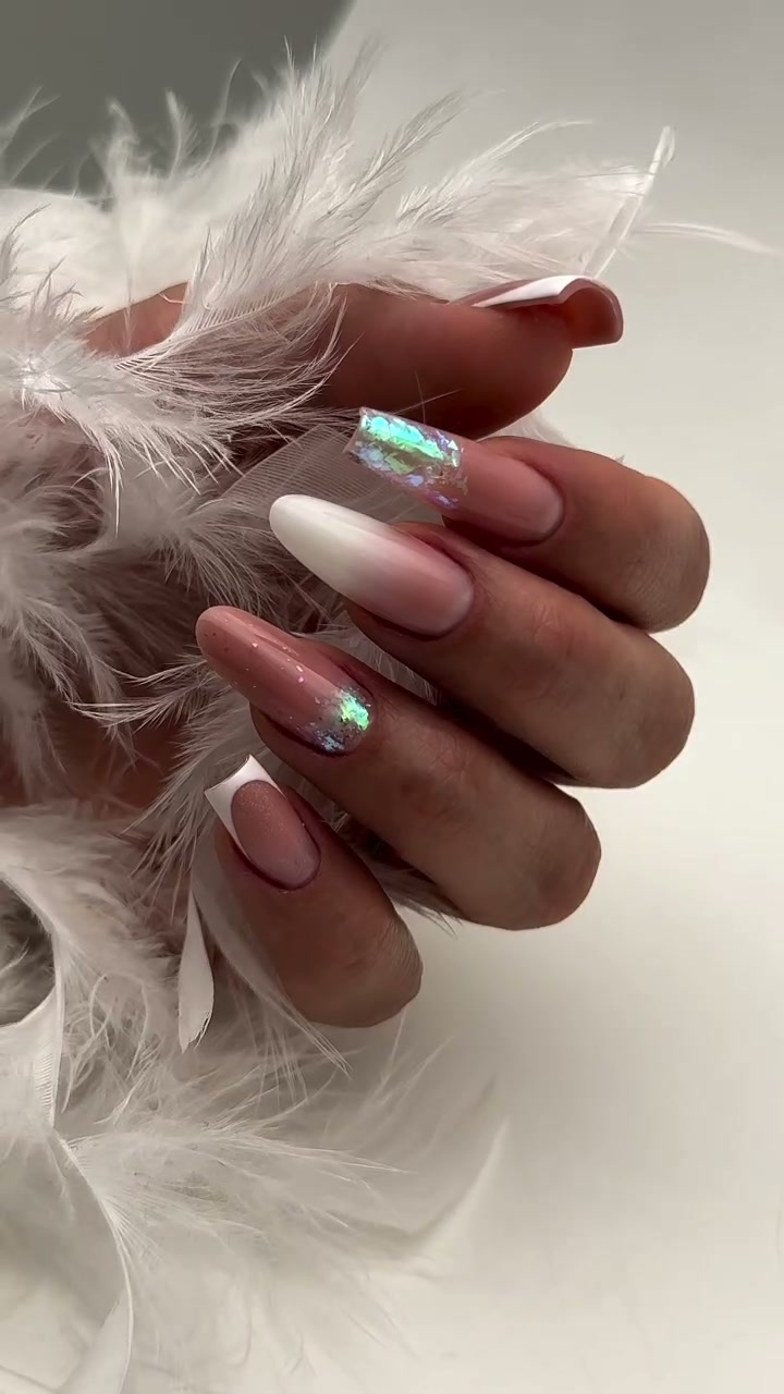 Mano con cinco uñas en tonos blanco y rosa con detalles iridiscentes